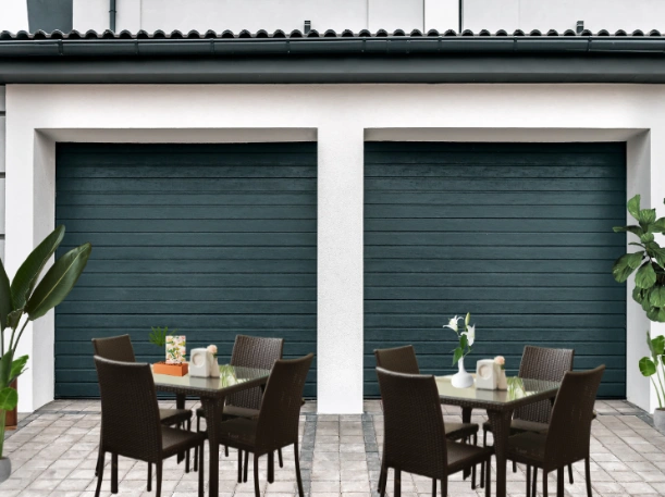 Architectural overhead doors with a horizontal wood-grain texture and a deep matte finish, creating a sophisticated backdrop for a restaurant patio or outdoor living space.