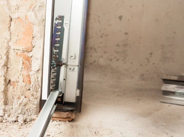 Detailed view of heavy-duty garage door track mounting hardware on a masonry wall, ensuring secure and stable door operation.