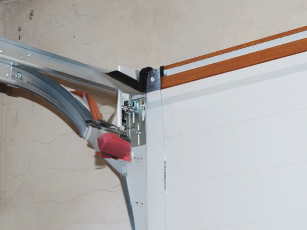 Close-up of a garage door side seal and professional track installation by Greer Garage Doors, showing a tight weatherstrip fit against a masonry wall.