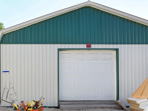 Garage door replacement for metal buildings in Greer, SC, showcasing a high-quality white sectional door on a custom steel outbuilding.